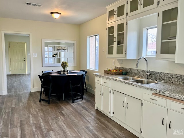 kitchen with dark hardwood / wood-style flooring, white cabinetry, and sink