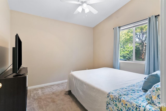 bedroom with a ceiling fan, vaulted ceiling, light colored carpet, and baseboards