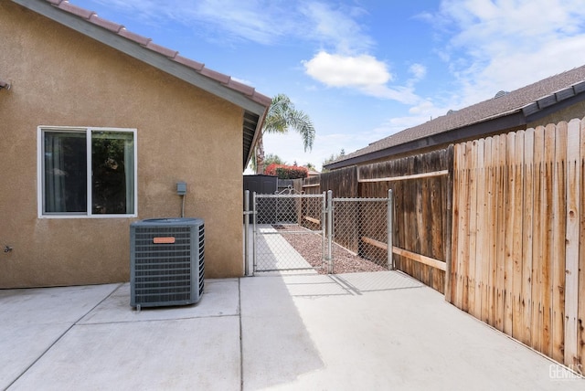 view of patio / terrace with a gate, central AC unit, and fence