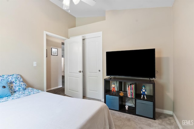 carpeted bedroom featuring a closet, baseboards, lofted ceiling, and a ceiling fan