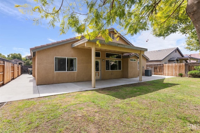 rear view of house featuring central air condition unit, stucco siding, a lawn, a fenced backyard, and a patio area