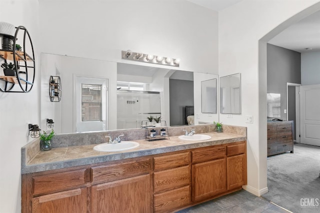 full bathroom with a sink, double vanity, a towering ceiling, and ensuite bathroom