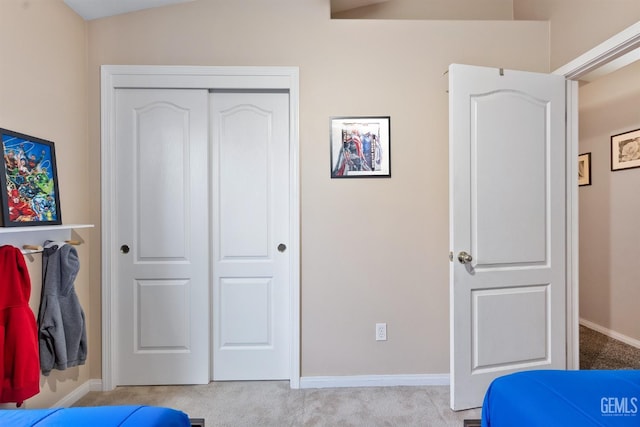 carpeted bedroom featuring a closet and baseboards