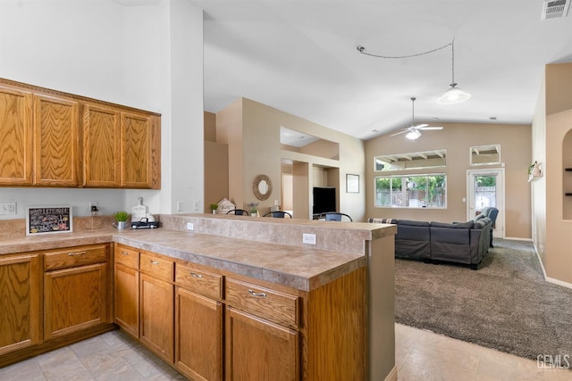 kitchen featuring visible vents, open floor plan, a peninsula, light countertops, and light colored carpet