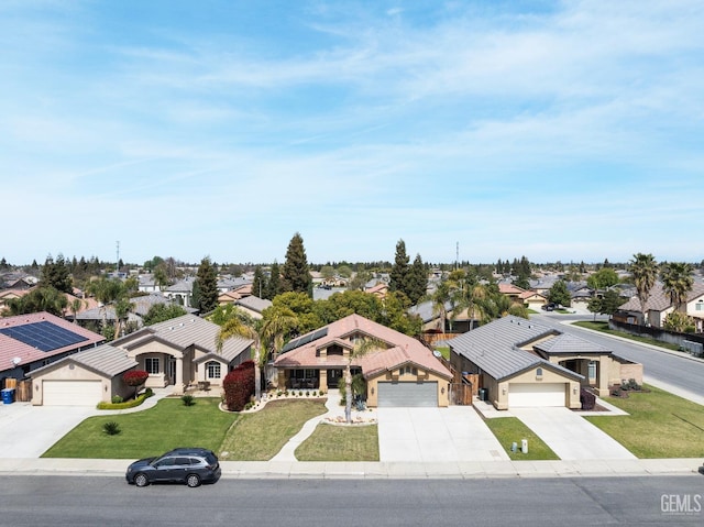 view of front of house featuring a residential view, an attached garage, and a front lawn