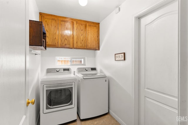 laundry room featuring cabinet space, baseboards, and washing machine and clothes dryer