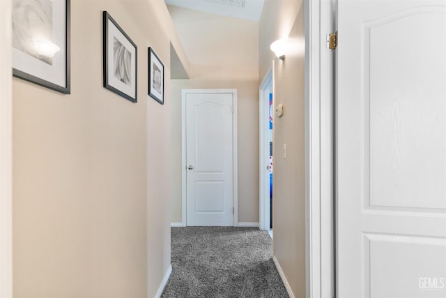 hall featuring carpet flooring and baseboards