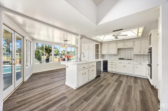 kitchen featuring kitchen peninsula, decorative backsplash, white cabinetry, ceiling fan, and sink