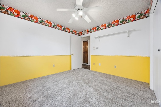 carpeted empty room featuring a textured ceiling and ceiling fan