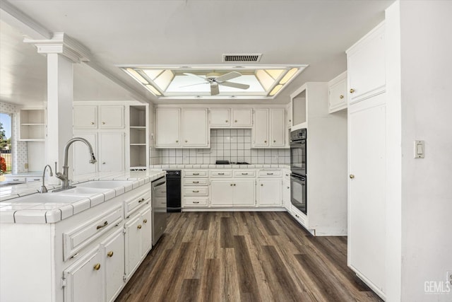 kitchen featuring gas stovetop, tile countertops, sink, white cabinets, and tasteful backsplash