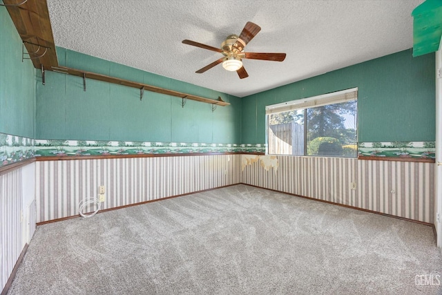 unfurnished room with a textured ceiling, ceiling fan, and light colored carpet