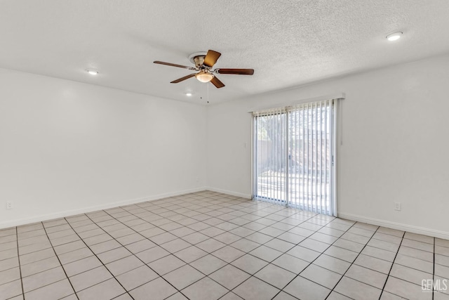 tiled spare room featuring a textured ceiling and ceiling fan