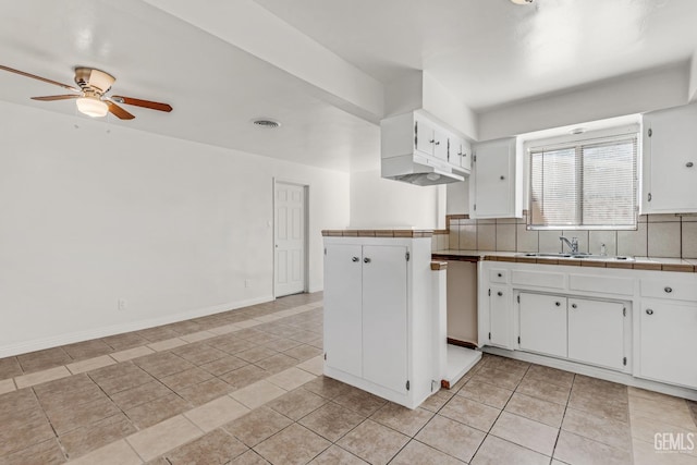 kitchen with tile countertops, light tile patterned floors, white cabinetry, and tasteful backsplash