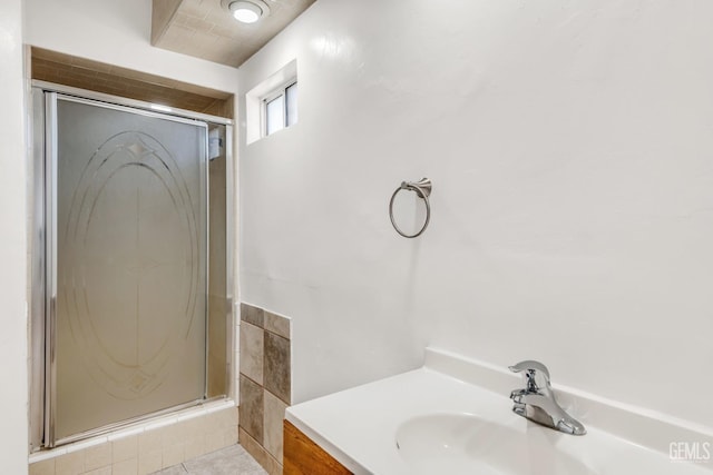 bathroom featuring a shower with door, tile patterned floors, and vanity