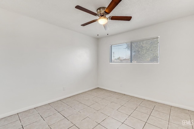 tiled empty room with ceiling fan and a textured ceiling