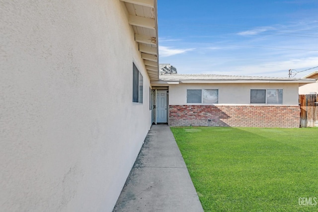 view of exterior entry featuring a yard