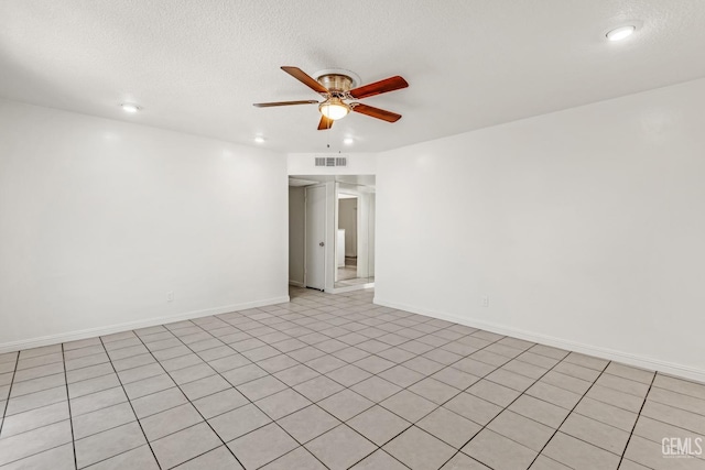 tiled spare room with a textured ceiling and ceiling fan