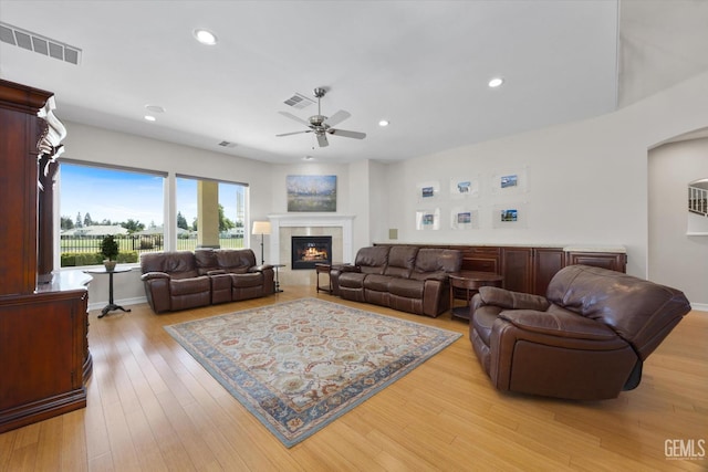 2120 Wedgemont Pl, Bakersfield, CA 93311 - living area with a ceiling fan, a tile fireplace, light wood-style flooring, recessed lighting, and arched walkways