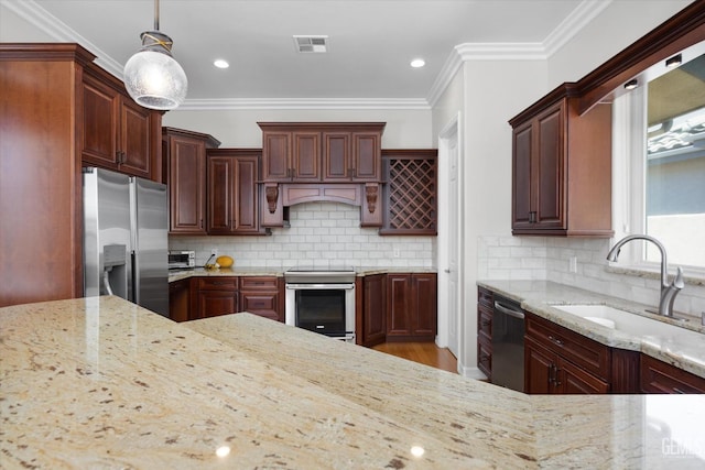 2120 Wedgemont Pl, Bakersfield, CA 93311 - kitchen featuring stainless steel appliances, light stone counters, ornamental molding, hanging light fixtures, and tasteful backsplash
