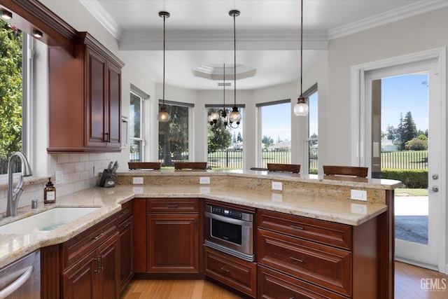 2120 Wedgemont Pl, Bakersfield, CA 93311 - kitchen with light wood-style flooring, stainless steel appliances, decorative backsplash, light stone counters, and crown molding
