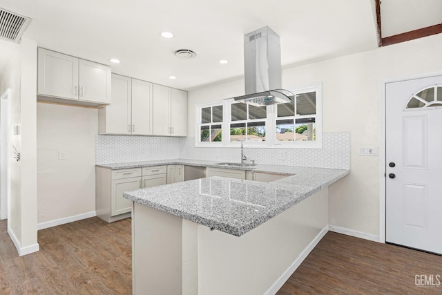 kitchen featuring visible vents, island range hood, dark wood-type flooring, and a sink