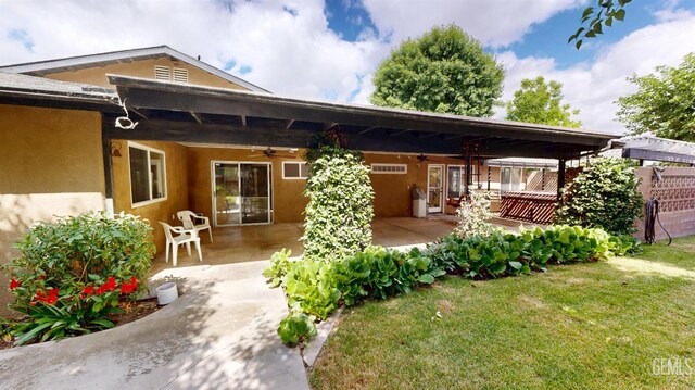 1334 Renfro Rd, Bakersfield, CA 93314 - back of house with ceiling fan, a lawn, a patio, and stucco siding