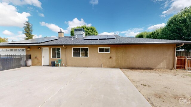1334 Renfro Rd, Bakersfield, CA 93314 - rear view of property featuring stucco siding, fence, roof mounted solar panels, a chimney, and an attached garage