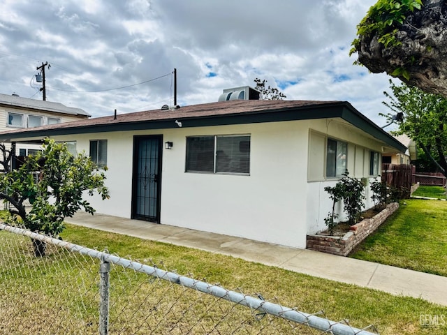 123 Ferguson Ave, Bakersfield, CA 93308 - back of property with a lawn, stucco siding, and fence