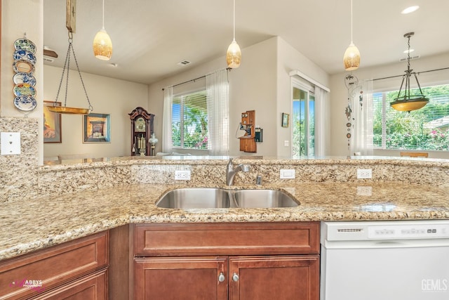 6100 Lassen Ridge Rd, Bakersfield, CA 93306 - kitchen featuring dishwasher, plenty of natural light, brown cabinetry, and light stone counters