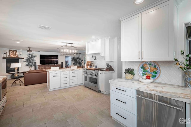 854 Vineland Rd, Bakersfield, CA 93306 - kitchen with appliances with stainless steel finishes, a peninsula, open floor plan, tasteful backsplash, and white cabinetry
