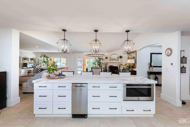 854 Vineland Rd, Bakersfield, CA 93306 - kitchen with open floor plan, light stone counters, white cabinetry, and hanging light fixtures