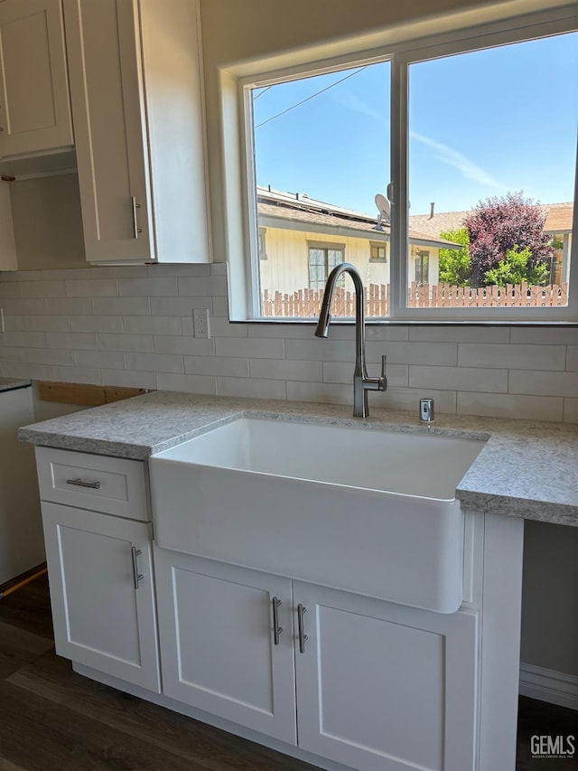 kitchen featuring white cabinets, sink, decorative backsplash, light stone counters, and dark hardwood / wood-style flooring