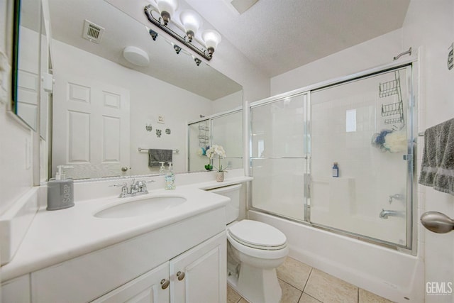 full bathroom featuring vanity, tile patterned floors, toilet, enclosed tub / shower combo, and a textured ceiling