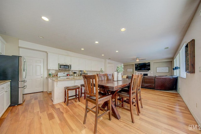 dining room with light wood-type flooring and ceiling fan