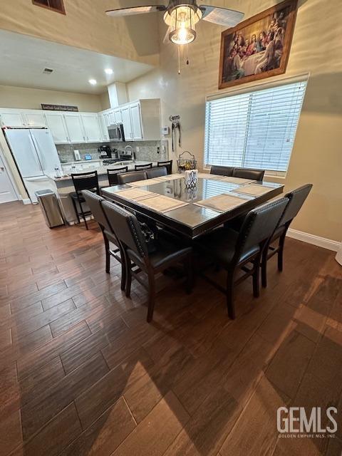 dining room featuring ceiling fan, a high ceiling, and hardwood / wood-style floors