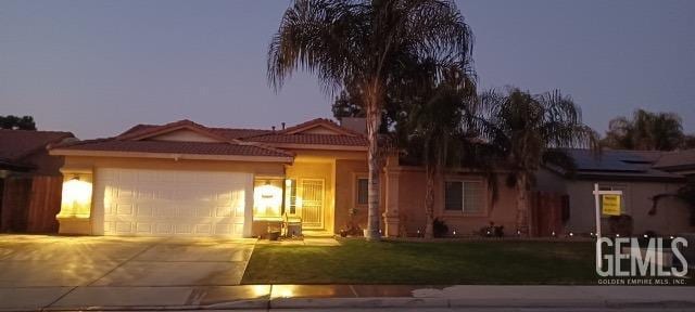 view of front of home with a yard and a garage