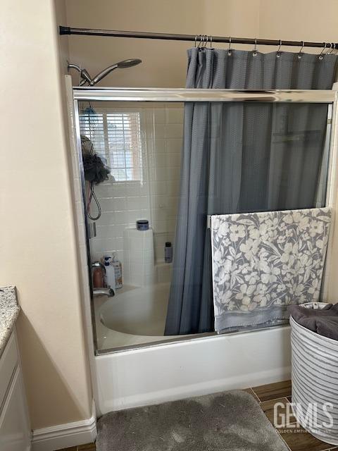 bathroom featuring hardwood / wood-style flooring, shower / tub combo, and vanity