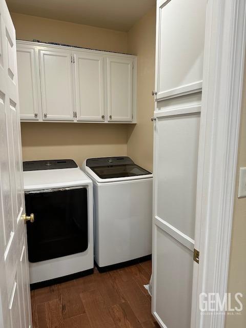 laundry area with independent washer and dryer, cabinets, and dark hardwood / wood-style floors