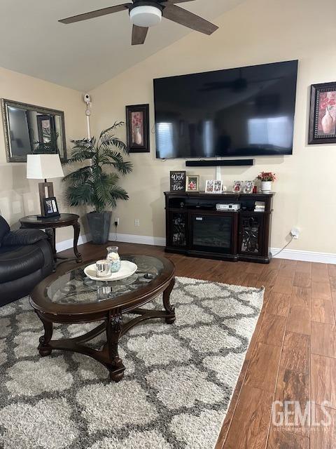 living room with ceiling fan, hardwood / wood-style flooring, and lofted ceiling