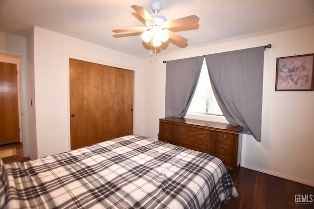 bedroom featuring a textured ceiling, dark hardwood / wood-style floors, a closet, and ceiling fan