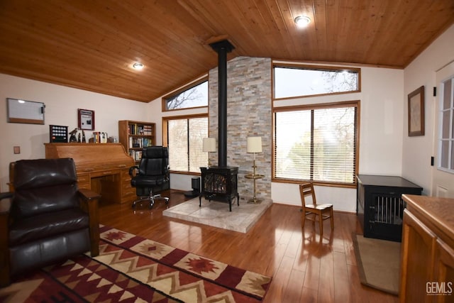 office space featuring hardwood / wood-style flooring, a wood stove, wood ceiling, and vaulted ceiling