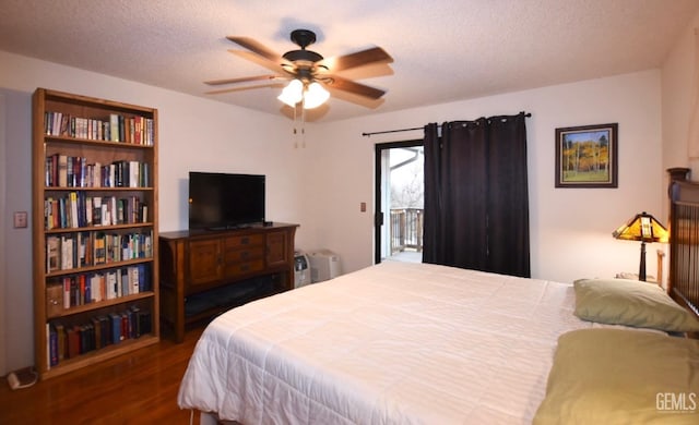 bedroom with ceiling fan, dark hardwood / wood-style flooring, and a textured ceiling