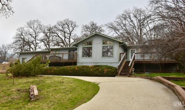 rear view of house featuring a yard and a wooden deck