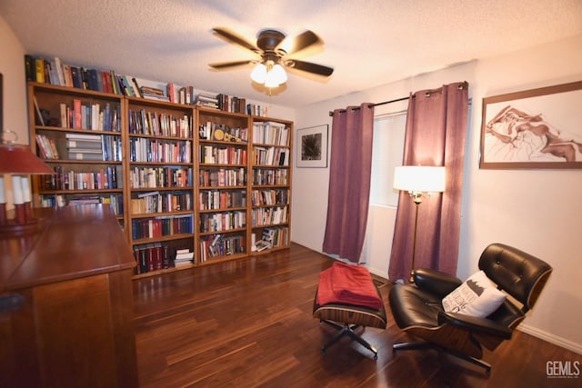 sitting room with dark hardwood / wood-style flooring, a textured ceiling, and ceiling fan