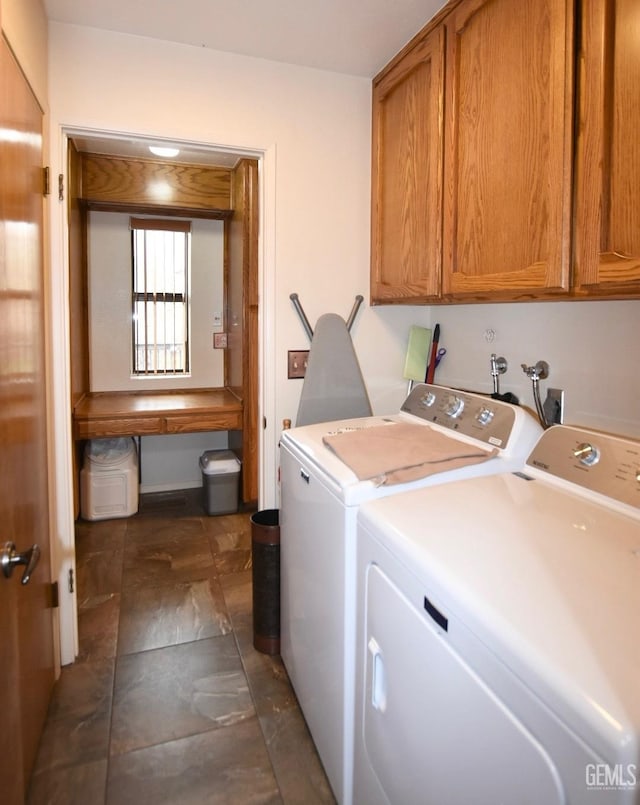 laundry room with washing machine and clothes dryer and cabinets