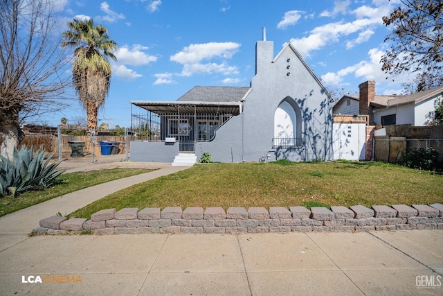 view of front of house featuring a front lawn, fence, and stucco siding