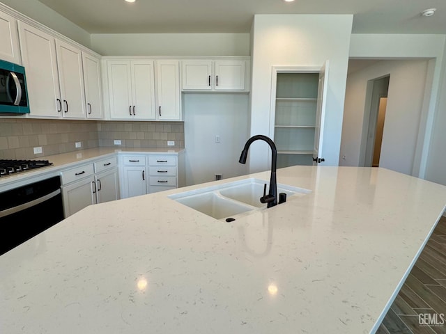 2411 Addlington St, Bakersfield, CA 93311 - kitchen with oven, gas cooktop, stainless steel microwave, light stone counters, and white cabinetry