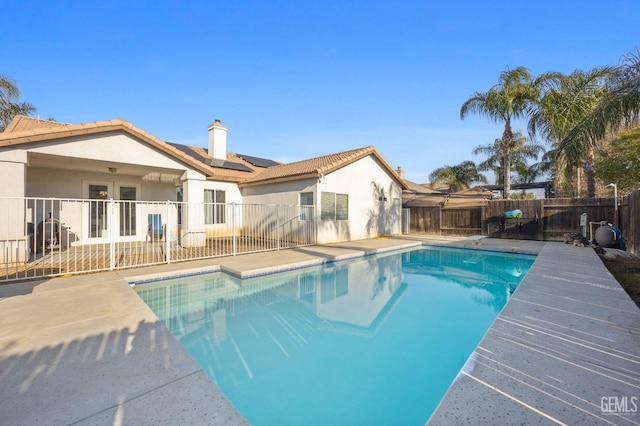 view of swimming pool featuring fence, a fenced in pool, and french doors