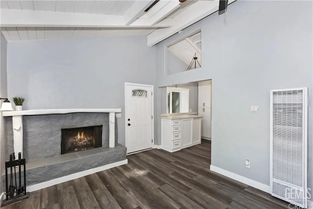 unfurnished living room featuring vaulted ceiling with beams and dark hardwood / wood-style flooring