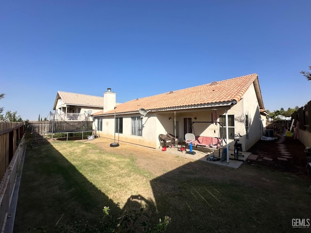 325 Terriwood Ave, Bakersfield, CA 93308 - back of property with a patio, a yard, and a trampoline